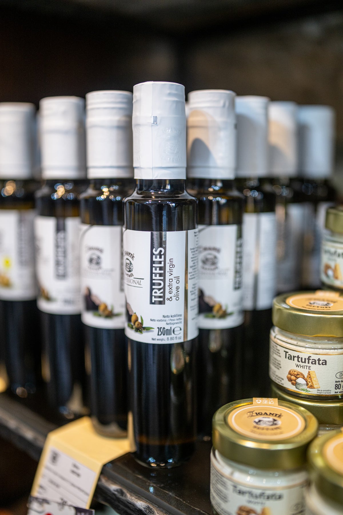 Shop shelf displaying extra virgin olive oil with truffles oils, and tartufata white with white truffles inside Zigante Tartufi truffle shop in Motovun, Istria, Croatia